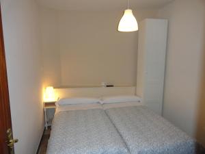 Dormitorio pequeño con cama y lámpara en Hostal Alistana, en Madrid