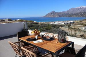 a wooden table with a bowl of fruit on a balcony at One Luxury House Above The Sea in Plakias