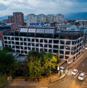 a large white building on a city street with buildings at Creamy Dreams by Dazzie in Skopje