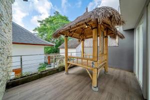 a porch with a thatch roof on a house at Modern 3BDR Villa - Between Canggu & Seminyak in Kerobokan