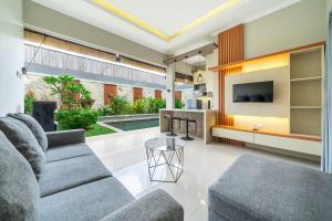 a living room with a couch and a tv at Modern 3BDR Villa - Between Canggu & Seminyak in Kerobokan