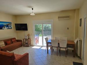 a living room with a table and chairs and a couch at Skala - Villa - Sleeps 7 - Parking - Garden in Skala Kefalonias