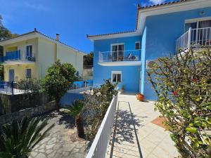a blue and white house with trees in front of it at Skala - Villa - Sleeps 7 - Parking - Garden in Skala Kefalonias