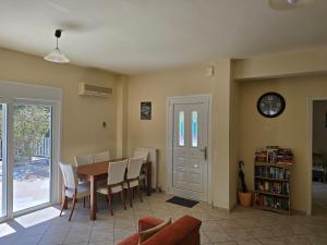 a dining room with a table and chairs and a clock at Skala - Villa - Sleeps 7 - Parking - Garden in Skala Kefalonias