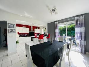een keuken en eetkamer met een zwarte tafel en stoelen bij Casa Bords de Loire in Mûrs-Érigné