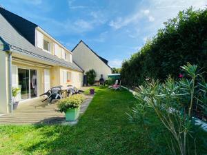 een achtertuin van een huis met een houten terras bij Casa Bords de Loire in Mûrs-Érigné