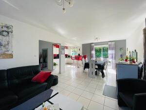 een woonkamer met een zwarte bank en een tafel bij Casa Bords de Loire in Mûrs-Érigné