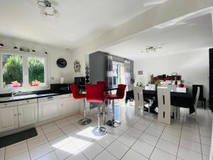 een keuken met een tafel en rode stoelen. bij Casa Bords de Loire in Mûrs-Érigné