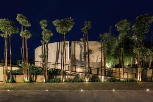 a building with a bunch of palm trees at night at Desagha Cabin in Bandung