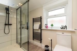 a bathroom with a shower and a toilet and a window at Victoria Cottage Seaside - Spacious 4-BR in Bognor Regis,close to Beachfront & 2 minutes from Butlins Holiday Camp in Felpham +58 photos
