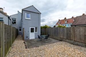 a backyard with a fence and a house at Victoria Cottage Seaside - Spacious 4-BR in Bognor Regis,close to Beachfront & 2 minutes from Butlins Holiday Camp in Felpham