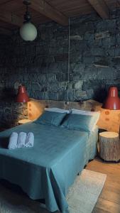 a bedroom with a blue bed with two pillows at Almorão in São Francisco de Paula