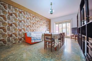 a dining room with a table and chairs and a wall at Front Stays Terracina Mare in Terracina
