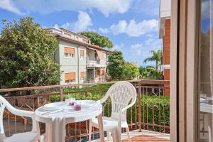 a white table and chairs on a balcony with a building at Front Stays Terracina Mare in Terracina