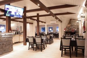 a dining room with tables and chairs and a flat screen tv at Holiday Village Inari in Inari
