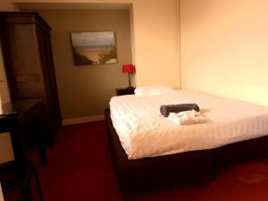 A bed or beds in a room at Hotel Kuiperduin