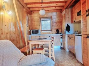 a small kitchen with a table in a cabin at Chalet Des Oursons, Capcir Pyrénées Catalanes in Puyvalador