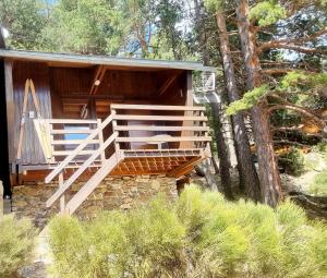 a wooden cabin with a staircase leading to a porch at Chalet Des Oursons, Capcir Pyrénées Catalanes in Puyvalador