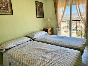zwei Betten in einem Zimmer mit Fenster in der Unterkunft Hornillo Vistas al Mar in Águilas