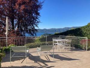 a patio with a table and chairs and a fence at Casa San Martino in Arizzano