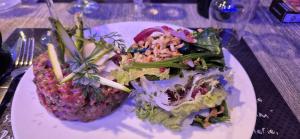 a plate of food with a salad on a table at Chalet LE CHEVREUIL Proche La Foux d'Allos in Villars-Colmars