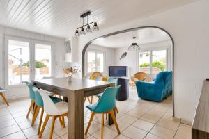 a dining room and living room with a table and chairs at Maison à Barbâtre pour 10 - 450m de la plage in Barbâtre