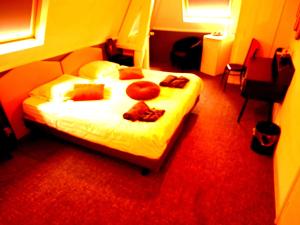 A bed or beds in a room at Hotel Kuiperduin