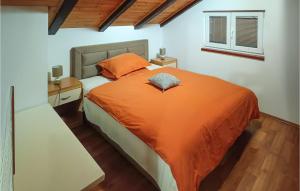 a bedroom with an orange bed and a window at Stunning Home In Gospic in Gospić