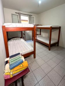 a room with two bunk beds in a room at Apartamento com vista pro mar no Centro de Ubatuba - com estacionamento 2 quartos e cozinha completa in Ubatuba +41 photos