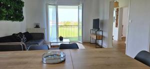 a living room with a table and a television at VIA ROMANA- Clim- à 5mn de la plage de sable in Prunelli-di-Fiumorbo +7 photos