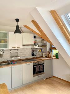 a kitchen with white cabinets and an attic at Apartment Iris in Bohinj