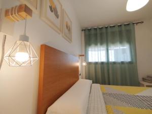 a bedroom with a bed and a green curtain at Apartamento Bahía Levante II Águilas in Águilas