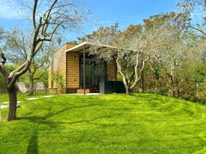 a house on a green lawn with trees at Seregnér Agricamping & Homes - Adults Only 18 in Monzambano