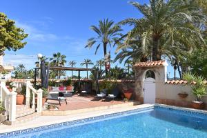 Los UrrutiasにあるVilla La Mariposaのヤシの木が茂るヴィラ内のスイミングプール