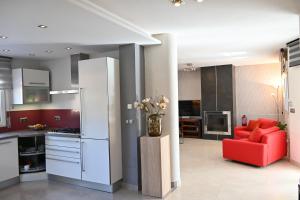 Los UrrutiasにあるVilla La Mariposaのキッチン、リビングルーム(赤いソファ付)