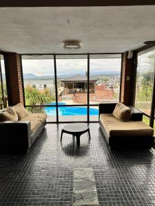 a living room with two couches and a table and a pool at Casa serrana in Villa Carlos Paz +5 photos