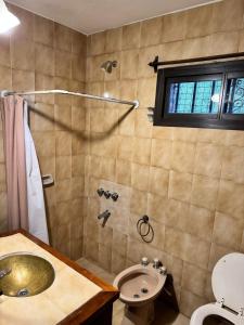 a bathroom with a shower and a sink and a toilet at Casa serrana in Villa Carlos Paz