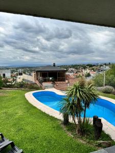 a view of a swimming pool and a house at Casa serrana in Villa Carlos Paz