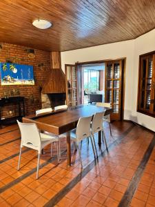 a dining room with a wooden table and chairs at Casa serrana in Villa Carlos Paz
