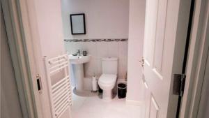 a white bathroom with a toilet and a sink at StayZo Modern Studio Apartment 1 in Bradford City in Bradford +5 photos