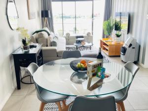 a living room with a glass table with a bowl of fruit at 2Bedroom Luxury Family Living Space in Midrand in Midrand