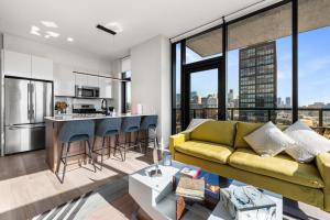 a living room with a green couch and a kitchen at Avra Stylish Apartments Prime West Loop Location Near Union Park in Chicago