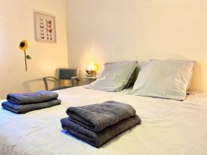 Una cama con toallas encima. en Terrasse de l'aber Roscoff, en Roscoff