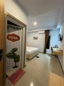 a hotel room with a bed and a sign on the door at Villa SIDAPORE JD in Lamobuang