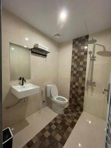a bathroom with a toilet and a sink and a shower at Villa SIDAPORE JD in Lamobuang
