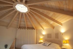 sypialnia z drewnianym sufitem i łóżkiem w obiekcie Mini casa con jardín w mieście Mungia
