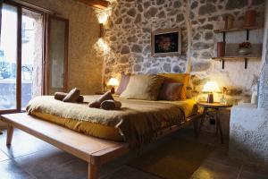 a bedroom with a large bed in a stone wall at CASA MIA - Maison et chambres à louer à Corbara in Corbara