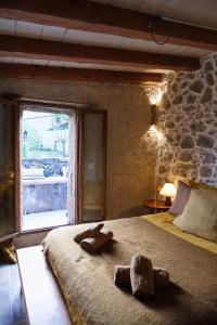 a bedroom with a large bed with a stone wall at CASA MIA - Maison et chambres à louer à Corbara in Corbara