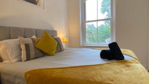 a bed with a yellow blanket and a window at De Parys Premier Lodge 3 in Bedford in Bedford