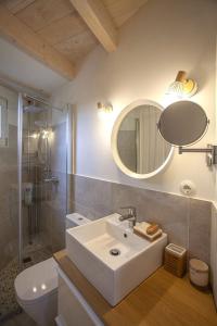 łazienka z umywalką, toaletą i lustrem w obiekcie Mini casa con jardín w mieście Mungia